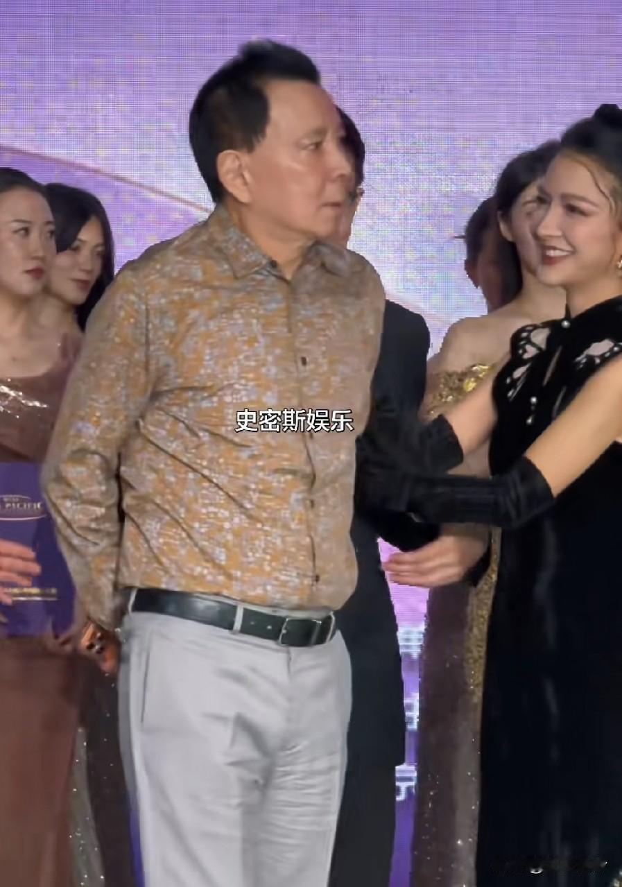 陈冠希爸爸陈泽民被拉上台，与亚洲小姐们同台合影，打量了一眼，这是不近女色啊！白衣