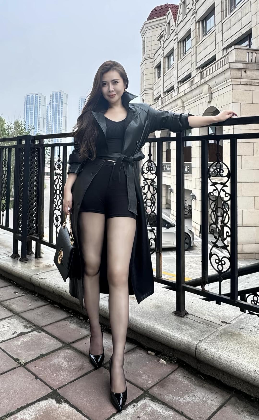 这姑娘穿着酷酷的黑色装，靠在栏杆上。