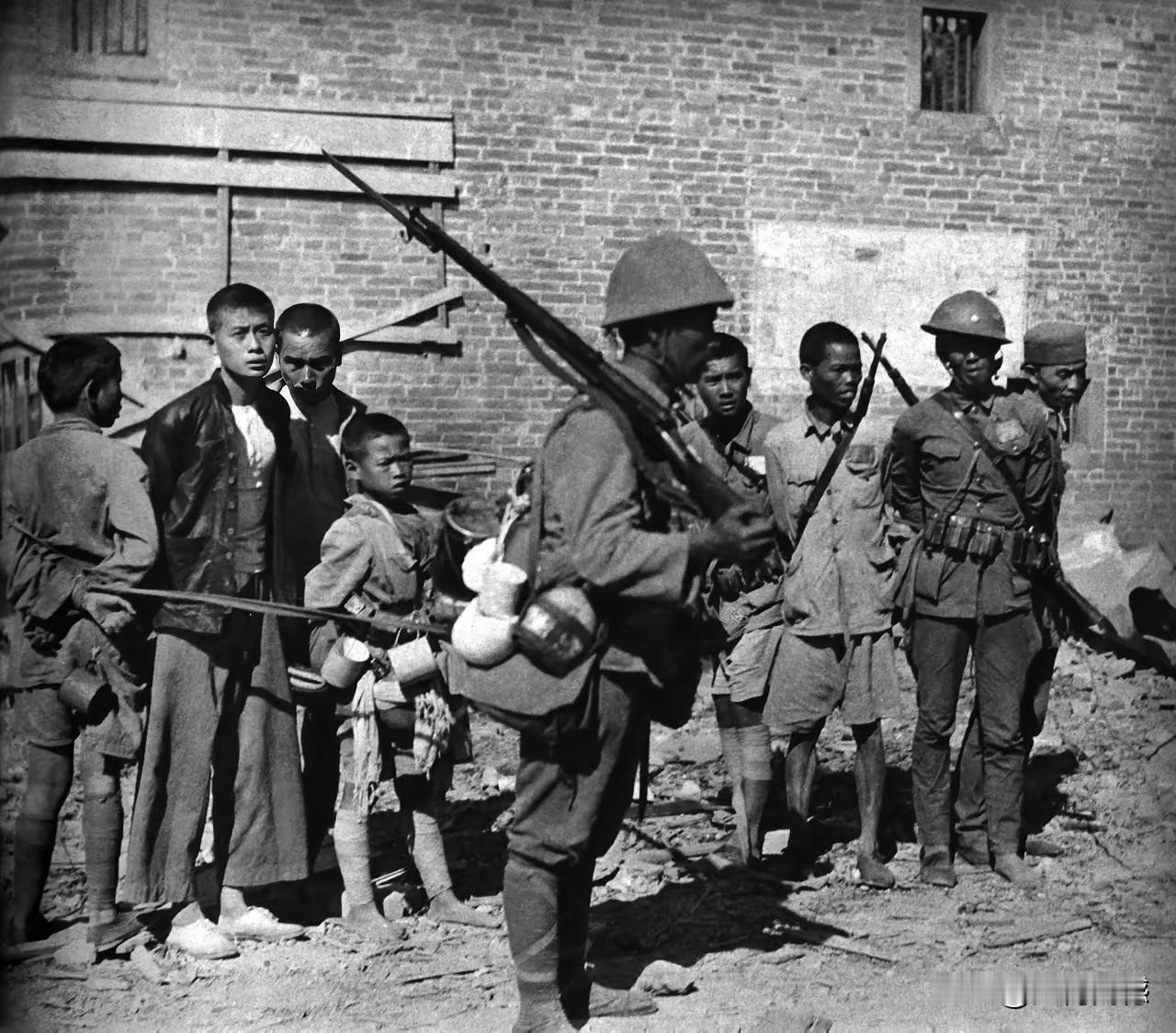 在这张照片中，我们能够看到，被日本鬼子俘获的这些人当中，还有一个未成年的孩子，看