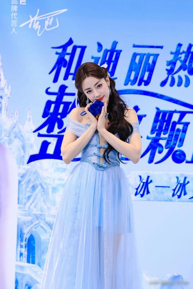 迪丽热巴，台上捂了一晚胸口。活动现场，闪光灯不停。她穿着那件露肩礼服，笑对镜