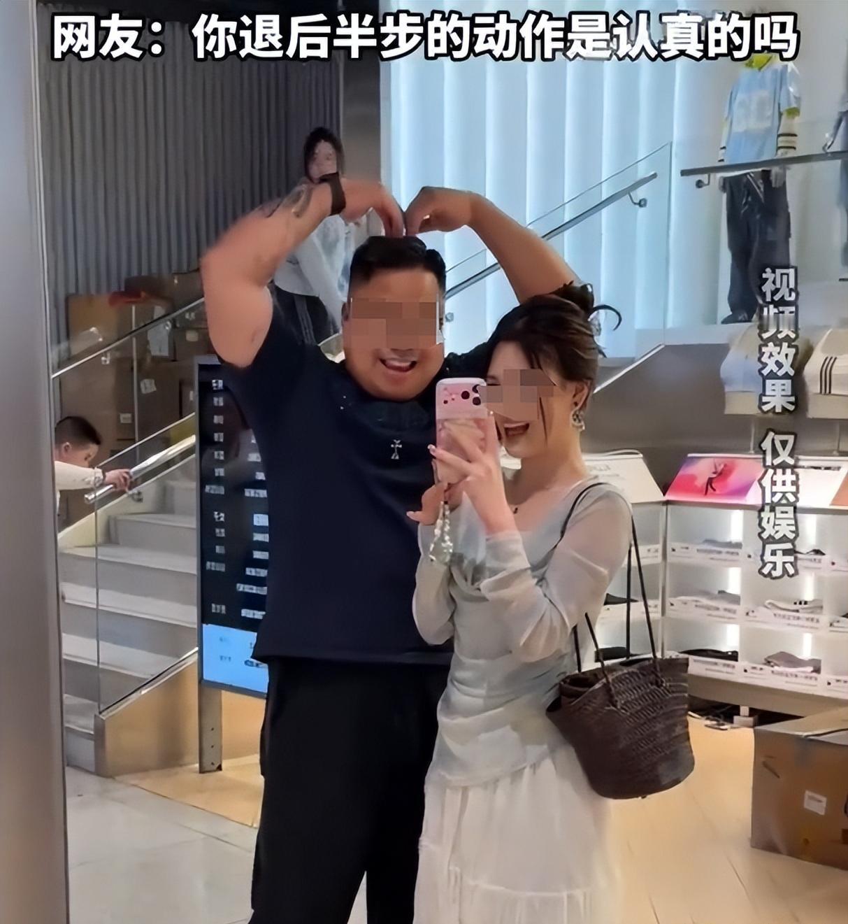 这女的喜欢的是男人的钱？一女子跟在丈夫后面逛街，二人停下来自拍，女子让丈夫做动作