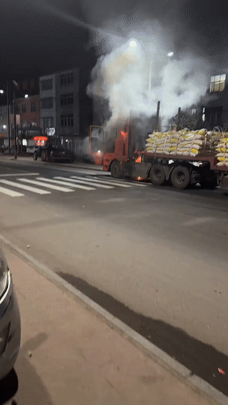 大货车在路边突然起火燃烧！货车司机手拿灭火器非常淡定从容的正在进行灭火。好在