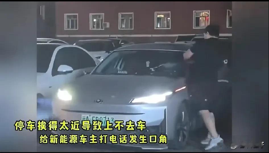 砸别人的车不会心痛!？黑衣男子的车被停在他旁边的新能源车别住了，