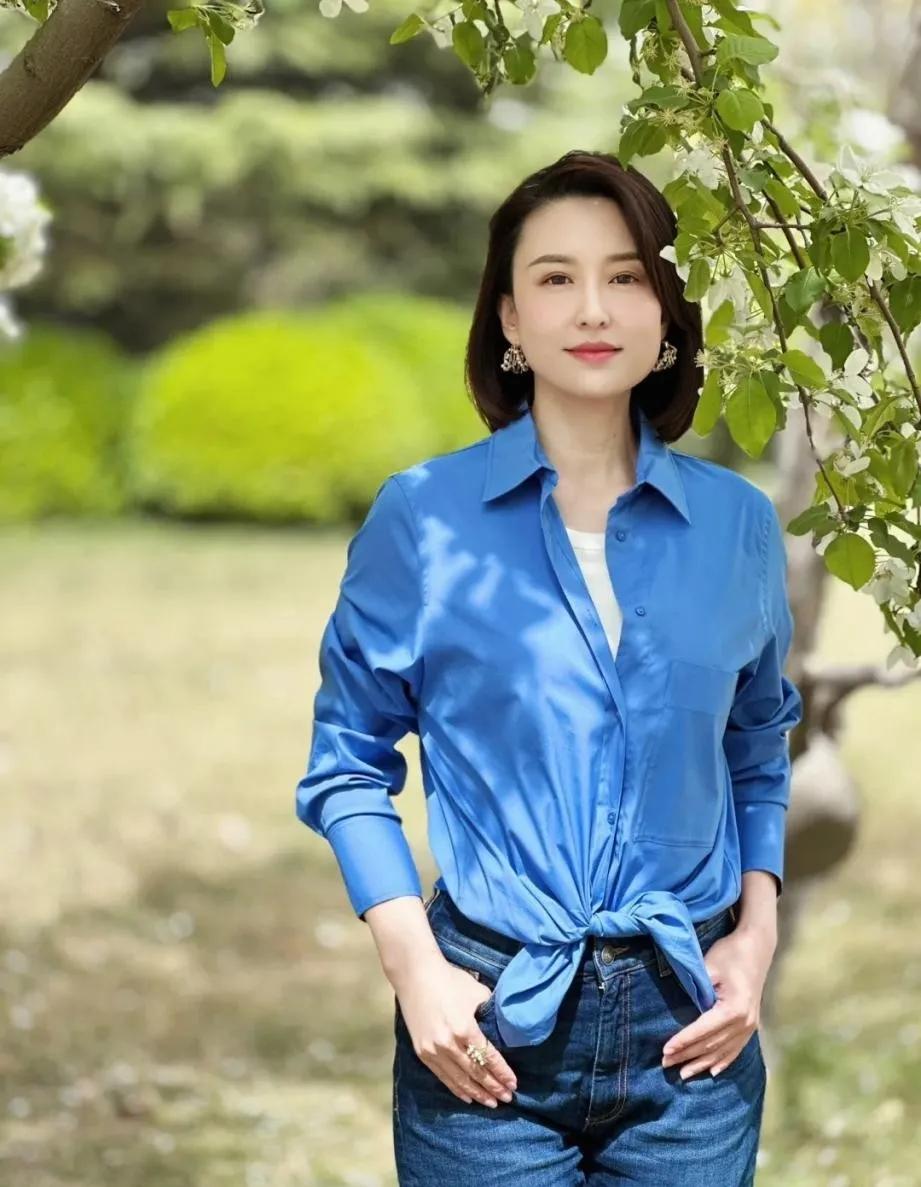 张蕾这穿搭真的太适合中年姐妹抄作业了！一件宝蓝色衬衫，下摆打个结，瞬间拉高腰线