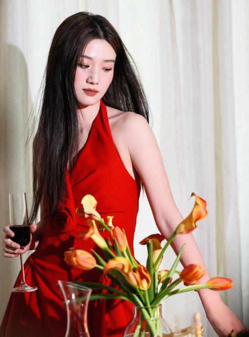 卢昱晓红裙卢昱晓工作室发布姐姐身着正红色挂脖连衣裙的造型，裙身点缀立体玫瑰装饰