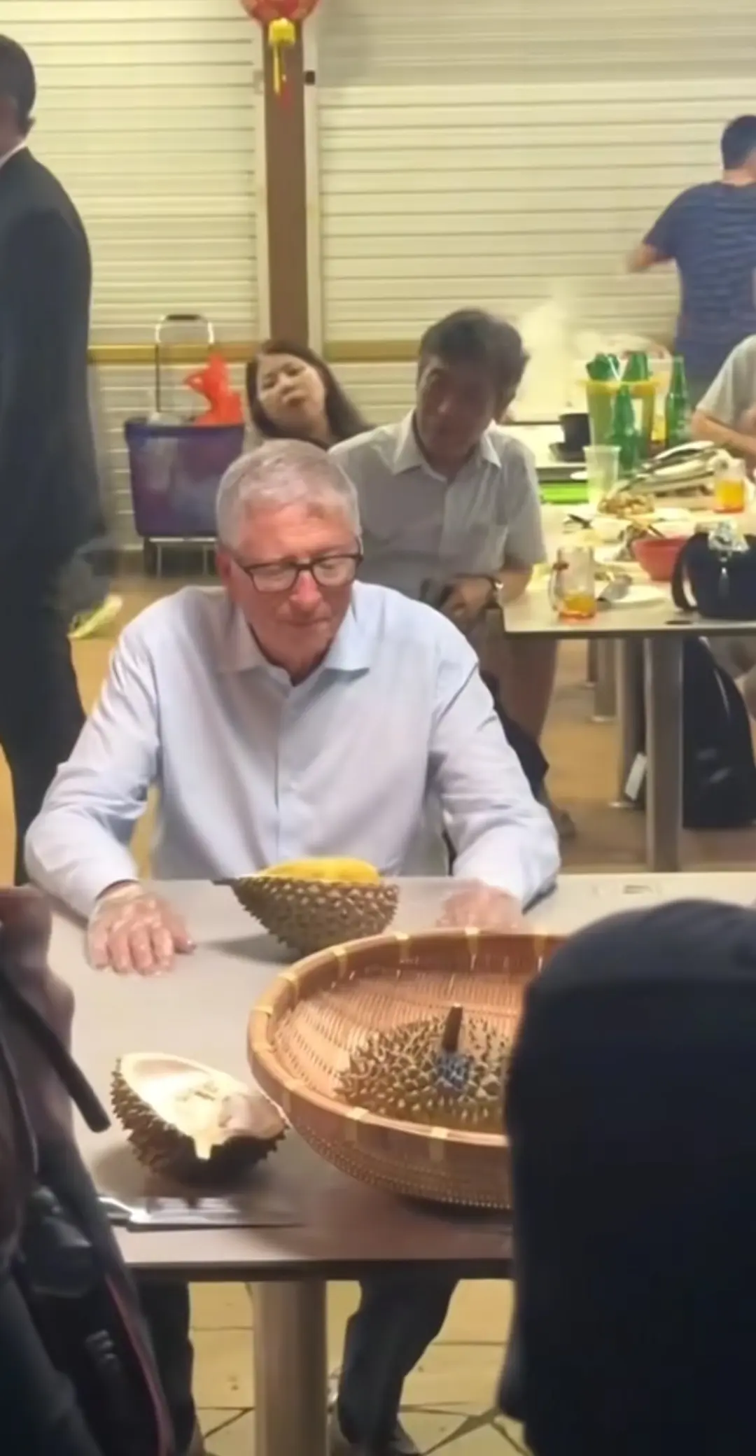 比尔盖茨看了半天榴莲，实在太臭了，但最终还是忍不住咬了一口。