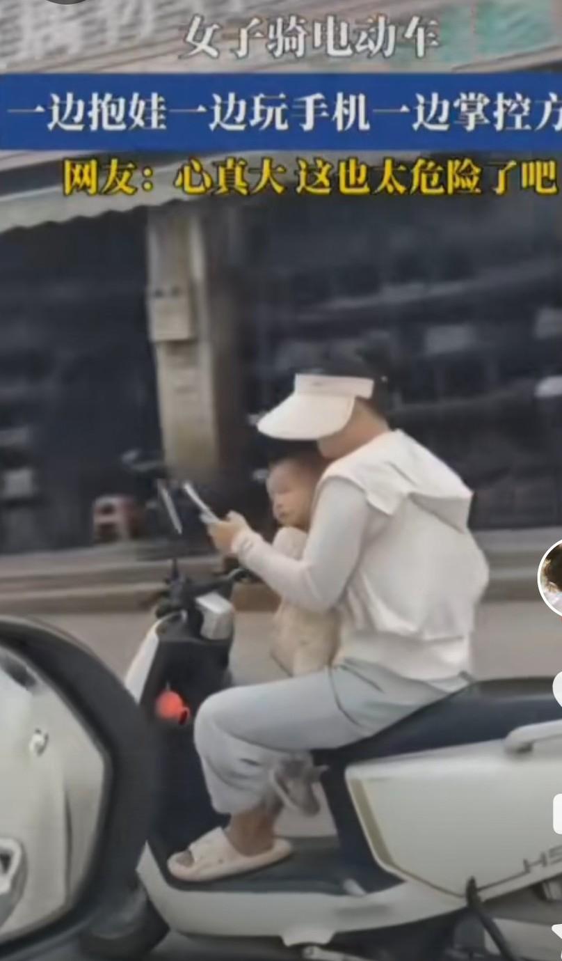 这位年轻妈妈可以去印度了。她趿着拖鞋，骑着电动车，左手刷着手机，右手边掌握电