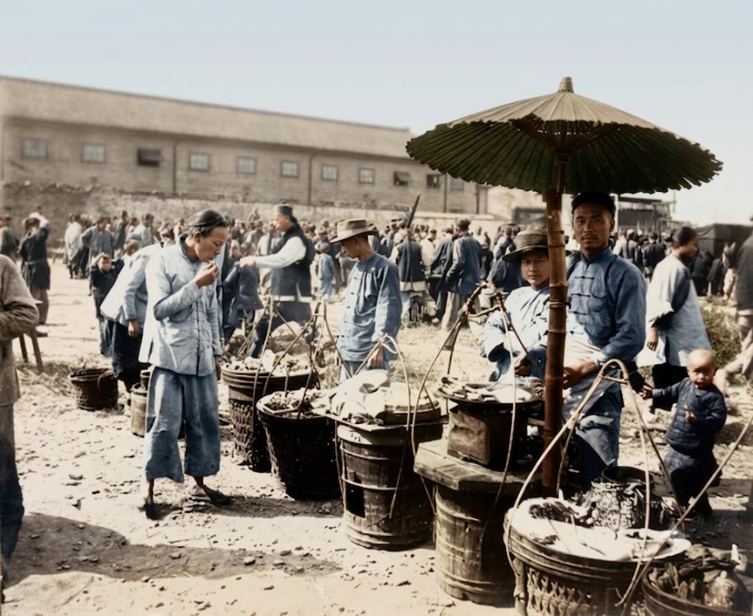 1902年，上海赛马日跑马厅外围热闹的露天市集，摊主支起老式油布大伞，木桶竹筐盛