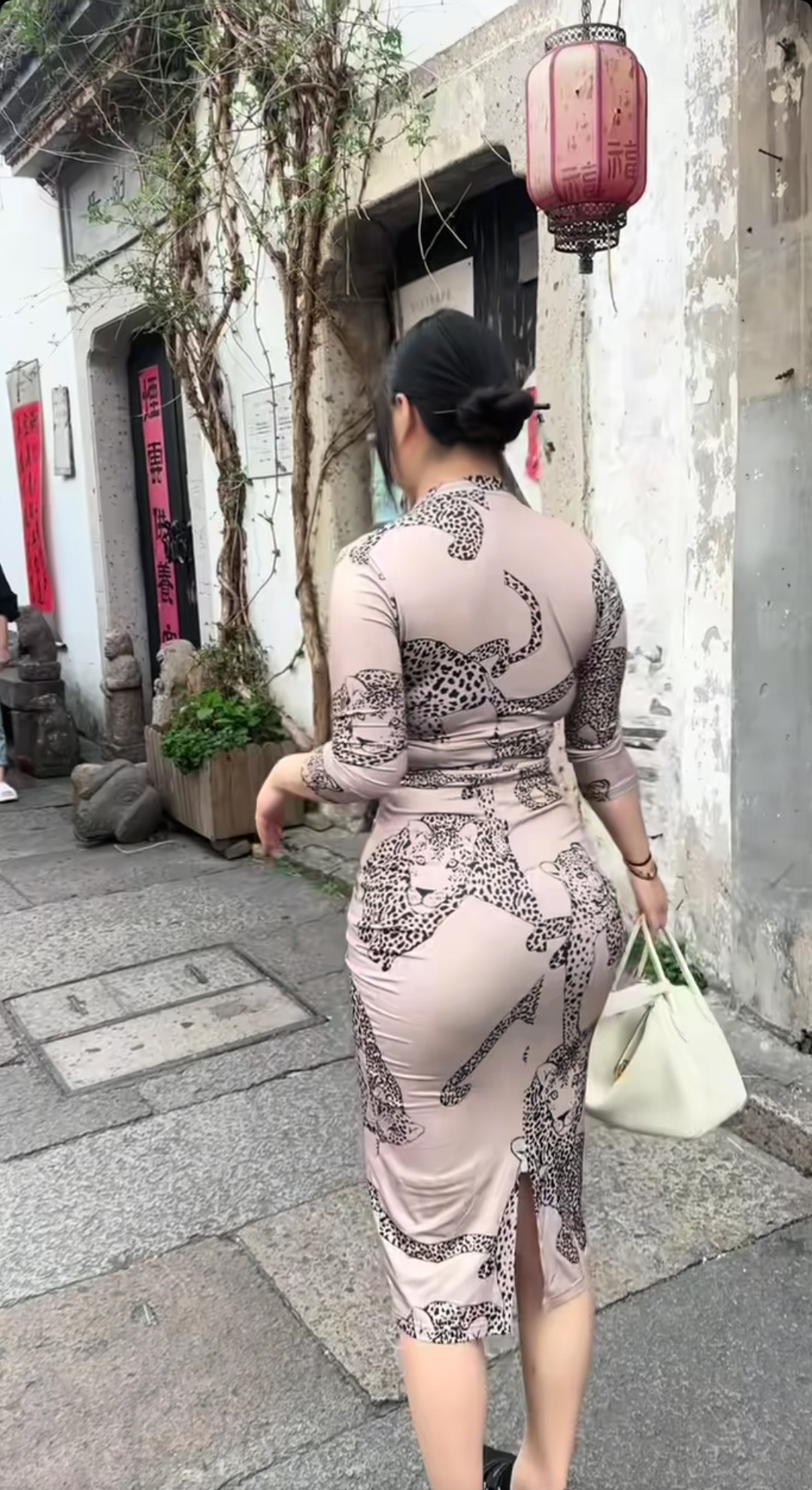 在古旧街巷，旗袍勾勒曲线，豹纹添了几分张扬。白墙、红灯笼作陪，传统与时尚碰撞，每一步都似在诉说：古典