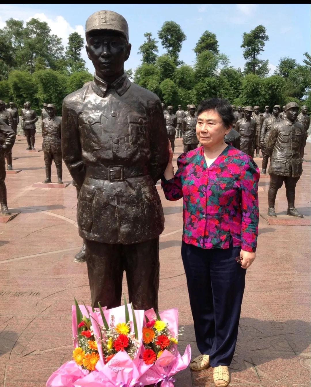 林晓霖祭奠父亲时，一张罕见的留影，在父亲的雕塑前放了一朵鲜花，寄托自己的哀思。