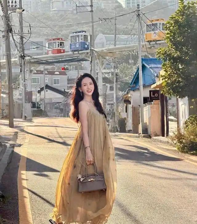 47岁的陈乔恩在釜山度假时美得让人移不开眼。她身穿一袭轻盈薄纱长裙，手挽爱马仕包