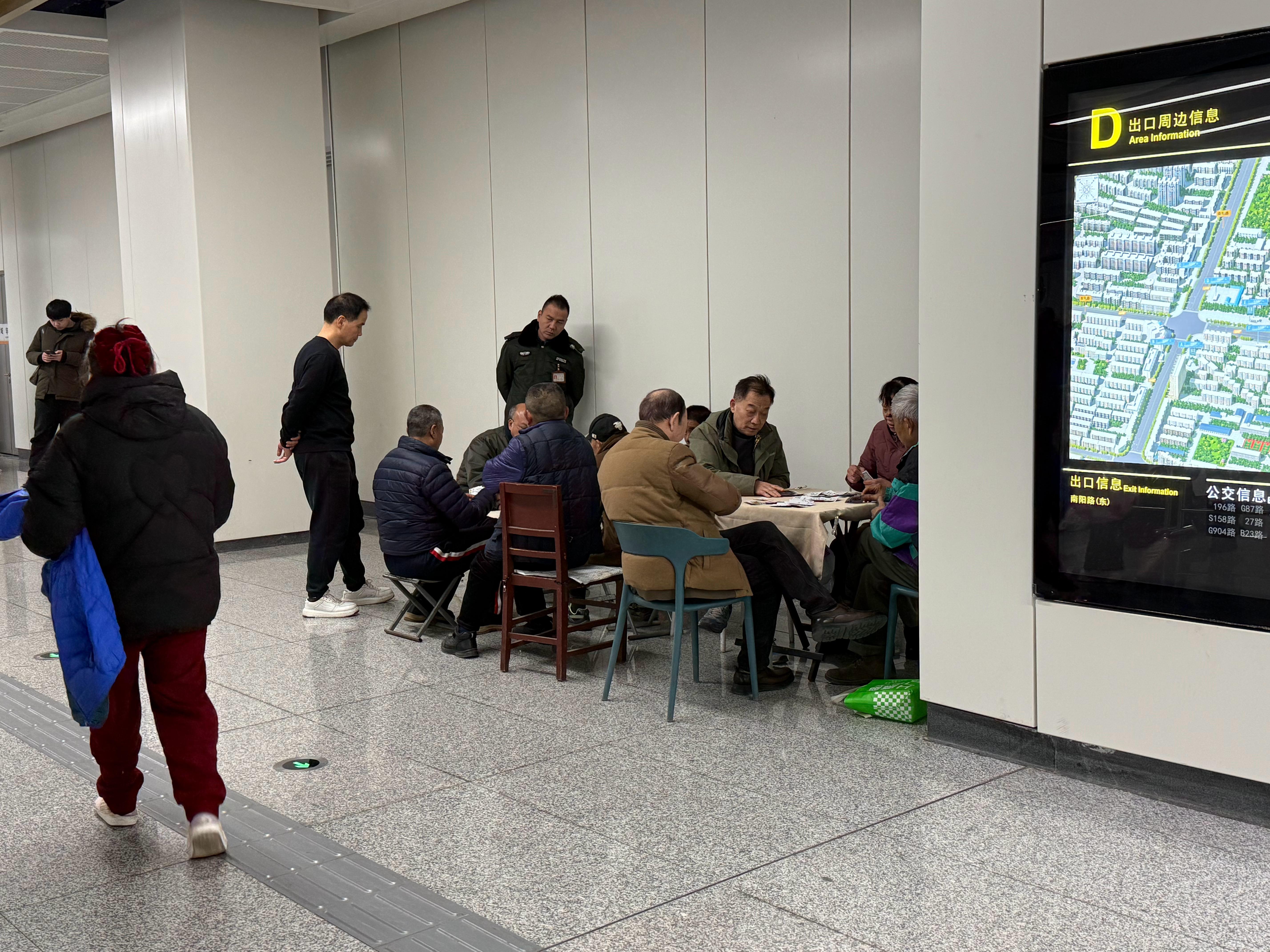 每次路过这个地铁口的时候，都能看到一堆人踢毽子、打麻将、打扑克、下象棋，这在地铁
