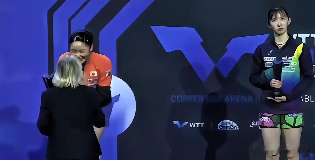 早田希娜和张本美和站得远远的，上扬的嘴角写满了落寞和不服。张本美和则满面春风，