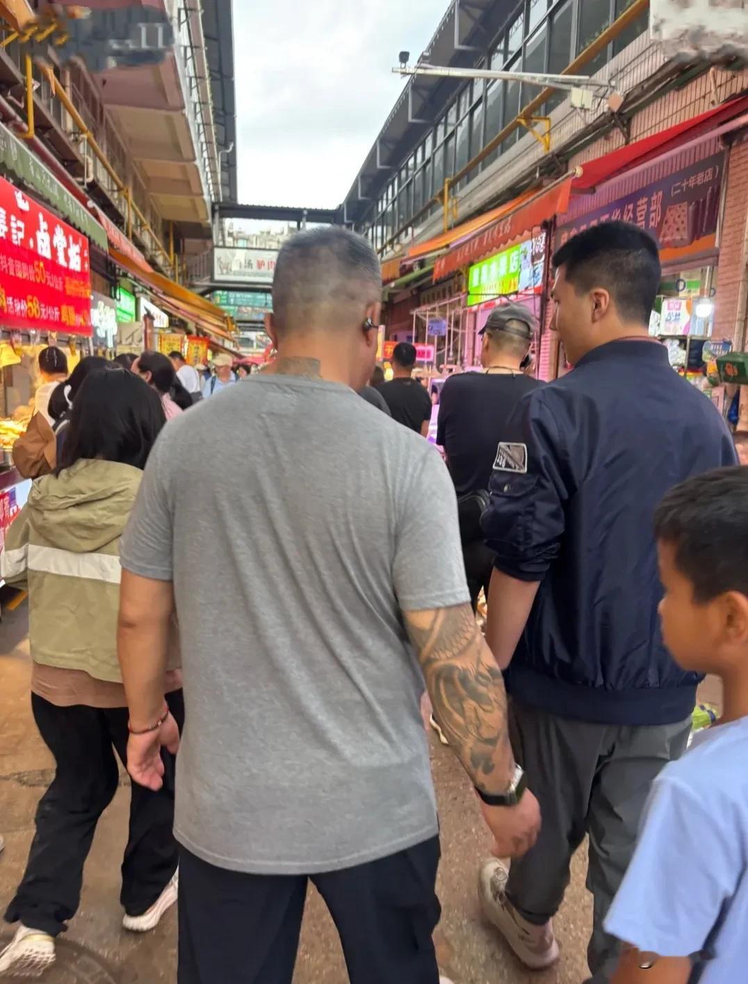 胡军儿子康康现身昆明一个菜市场，身材高挑身形壮实，好正能量的面相！他穿着一件墨