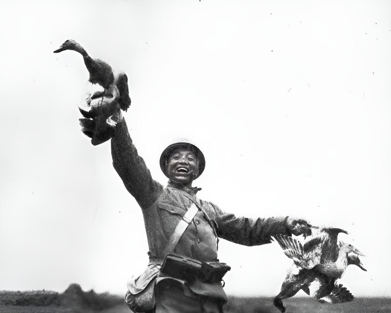 1937年11月18日，江苏傀儡湖畔，一个鬼子兵手拿从湖里抓获的附近百姓的鸭子向
