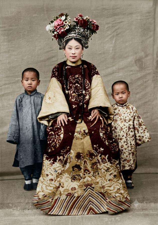 清末，一位受封的诰命夫人与她的两名幼子。这个诰命夫人身着全套盛装礼服，神态端肃，