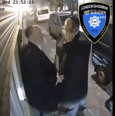 英国首都伦敦，2名犹太复国主义拉比在卷帘门前，其中1名在打电话，说“巴勒斯坦儿童