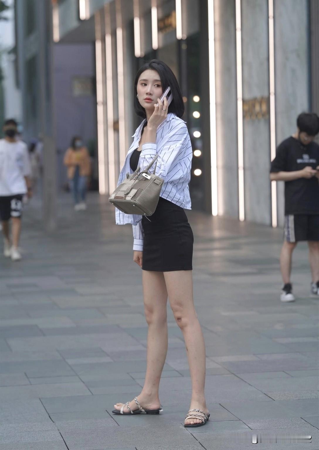 都市街头时尚穿搭，黑白条纹衬衫+黑色短裙，搭配简约手袋，优雅自信