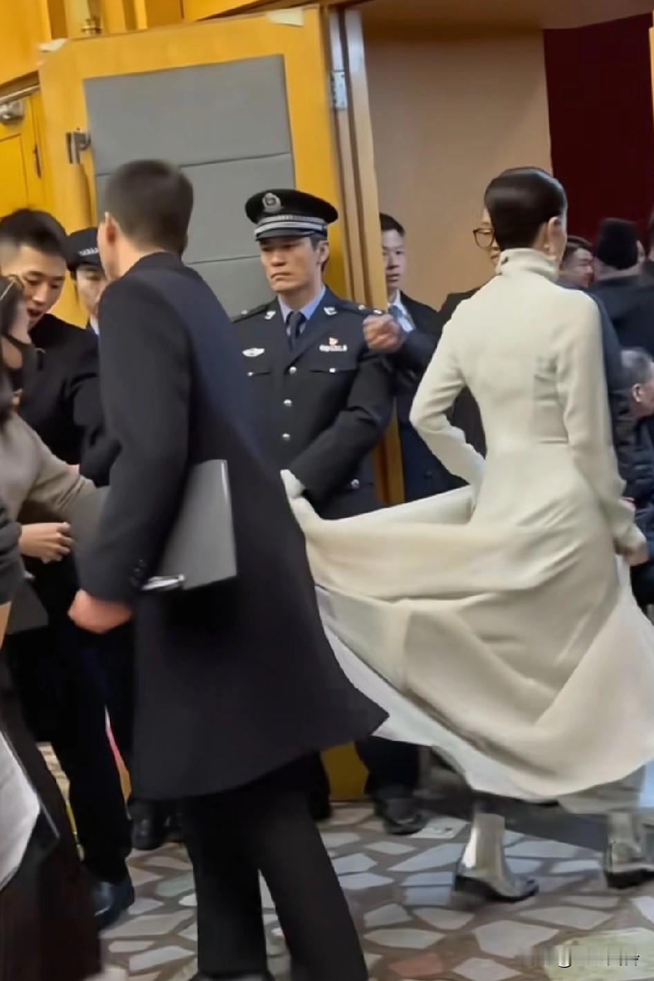 王菲的裙子被人拽着，她回头看了一眼，用力拽了一把就走了，最后那男的还踩到她裙子了