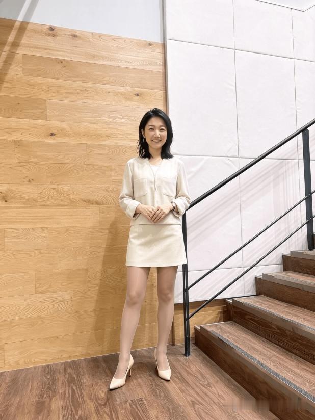 这位女士站在楼梯旁，微笑着。
