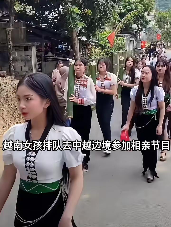 中越边境相亲活动现场，一大队越南姑娘排着长队步行赶往现场，姑娘们穿着特色民族服饰