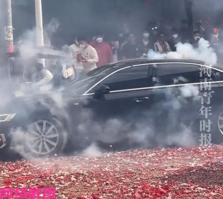 广西宾阳有男子开着自己的奥迪车，不小心经过当地的炮龙节，男子顺带想在一旁看个热闹