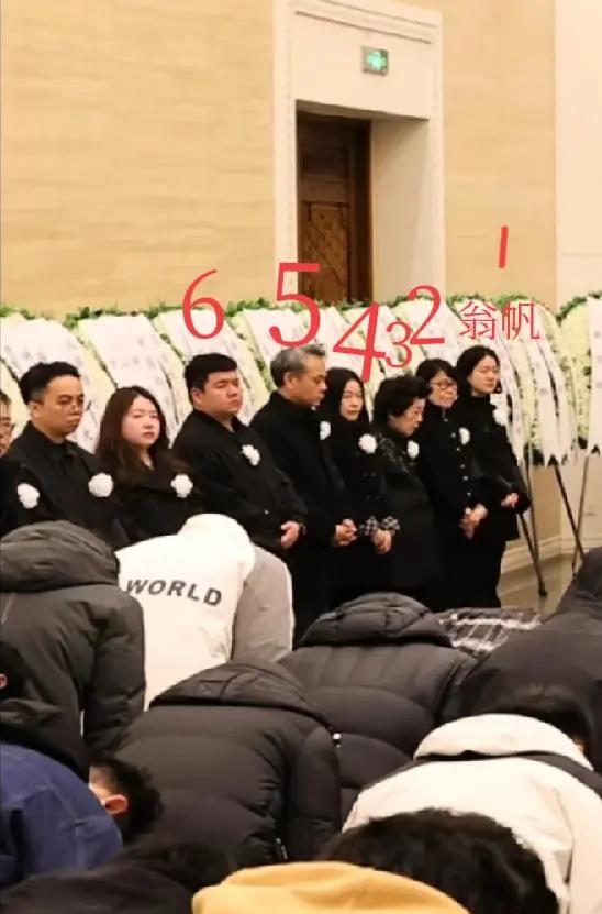 杨振宁告别会的家属区，墙边站了一排人。翁帆在最前头，第二个戴眼镜的女士看着像女儿