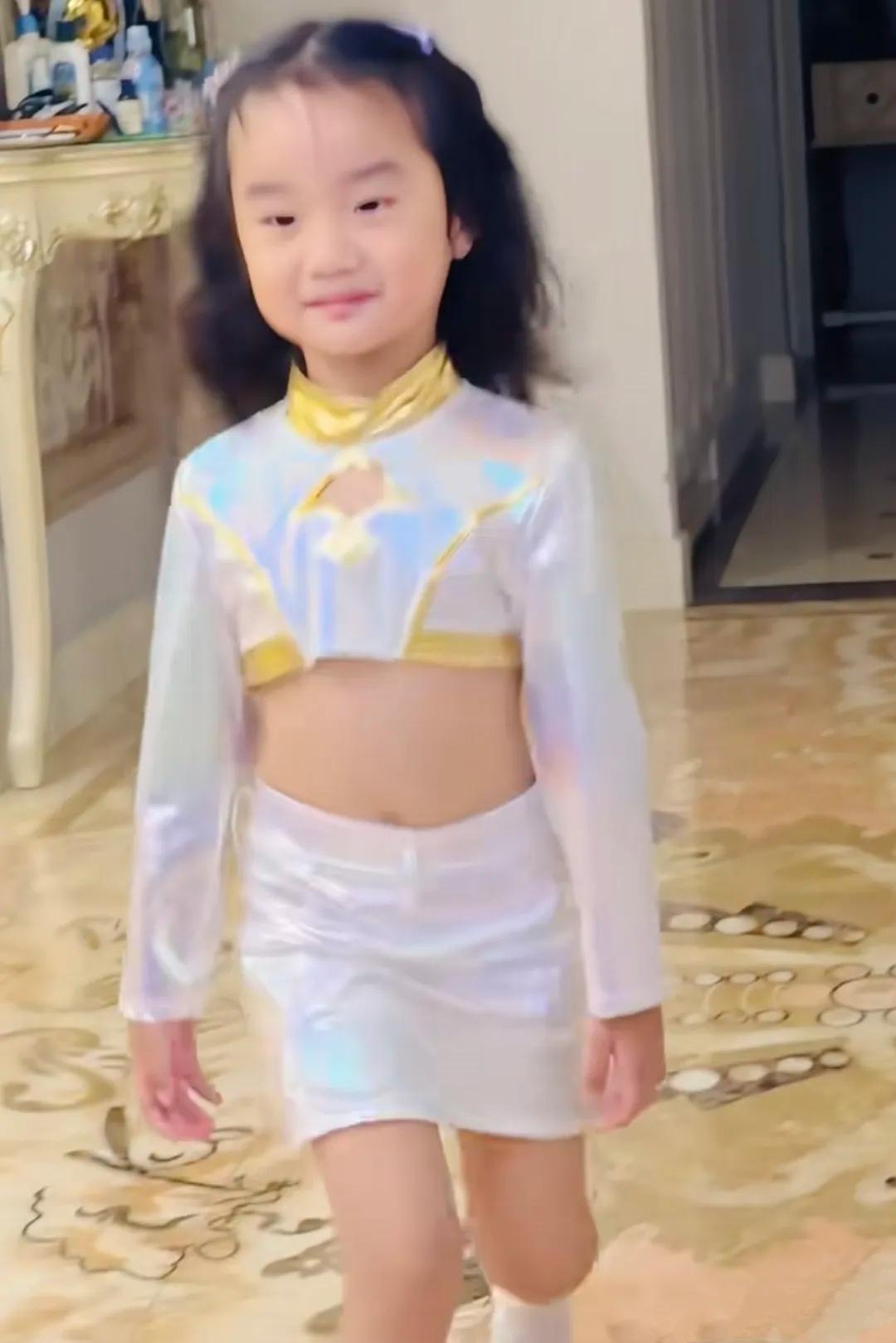 李亚鹏4岁的小女儿，在家里走秀。穿着演出服，踩着猫步，暑假刚烫了卷发，架势十