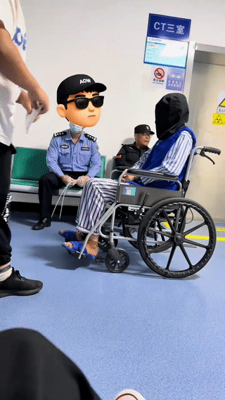 网友在医院里拍到一名坐着轮椅的犯人正在等待拍片子?看起来他应该是得了什么大病,
