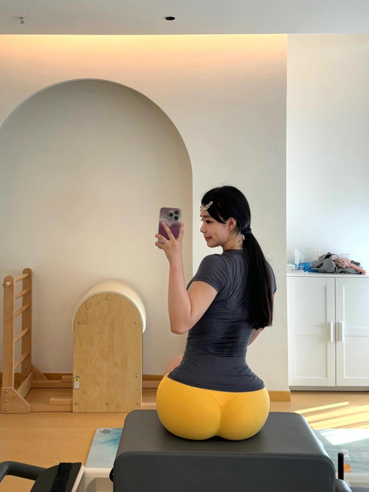 家人们谁懂啊！健身房偶遇的蜜桃臀女神也太顶了！灰T配亮黄瑜伽裤往训练架一坐，这腰