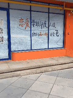 这是一位国内网友分享的视频，他出门看到个特别奇葩的宣传语，上面居然写着：念爱要跟