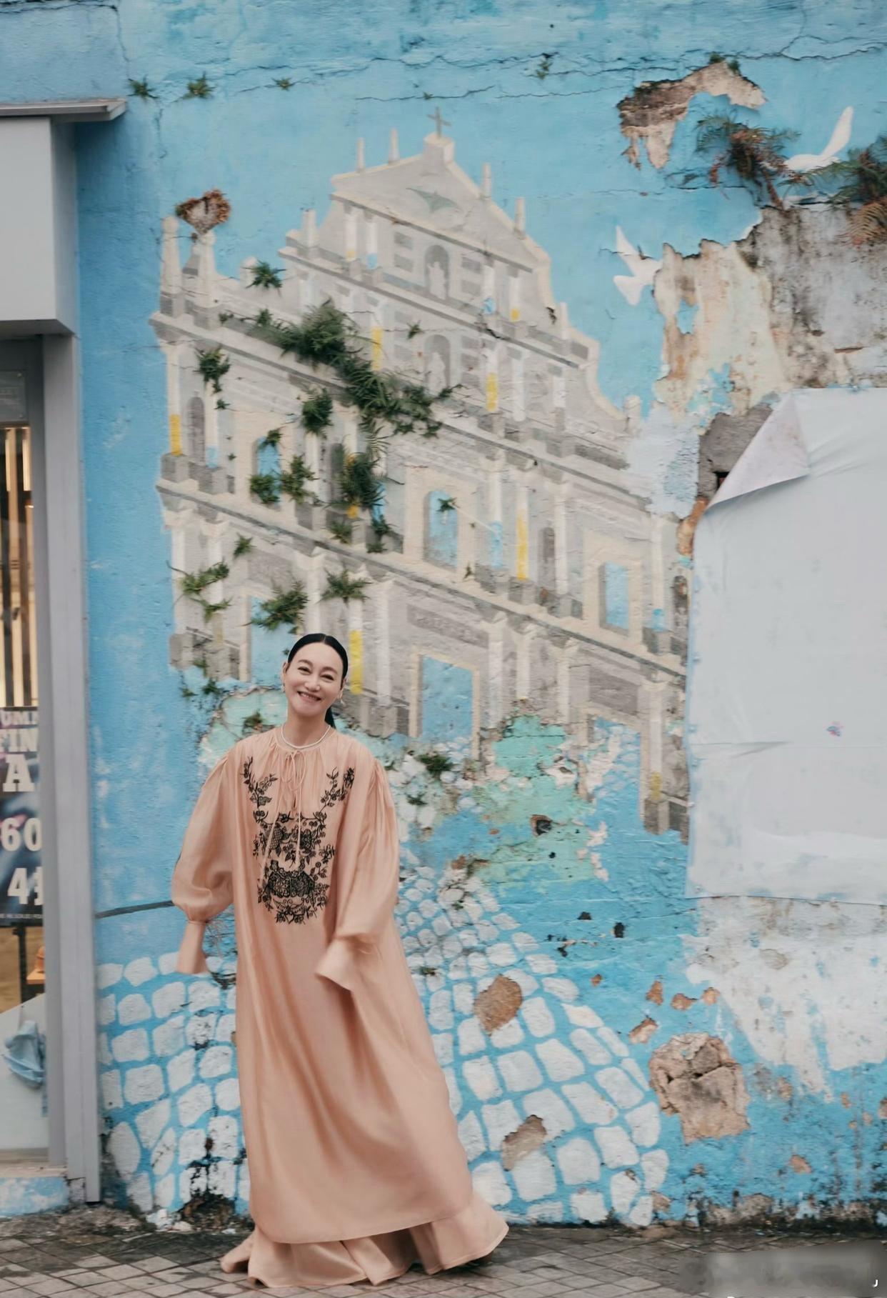 惠英红打卡澳门街头，身穿宽松连衣裙，明媚又温柔。镜头前是光鲜亮丽的明星，镜头外竟