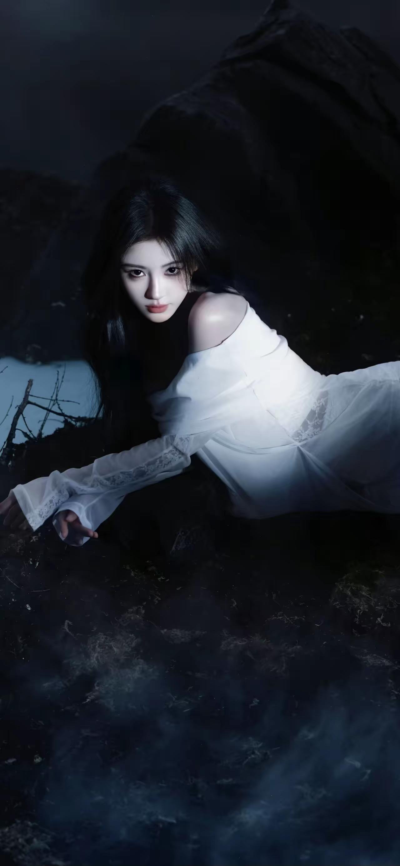夜雾漫过荒岩，白裙栖于山岚。鞠婧祎黑发如瀑，眼波似淬了寒星，在幽暗中漾开清冷的
