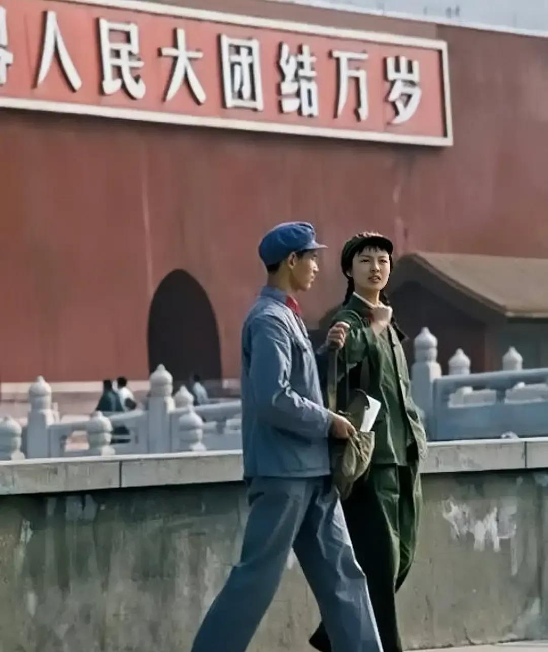 这是拍摄于上世纪七十年代的照片，画面中有两位解放军男女军人正在天安门城楼前行走。