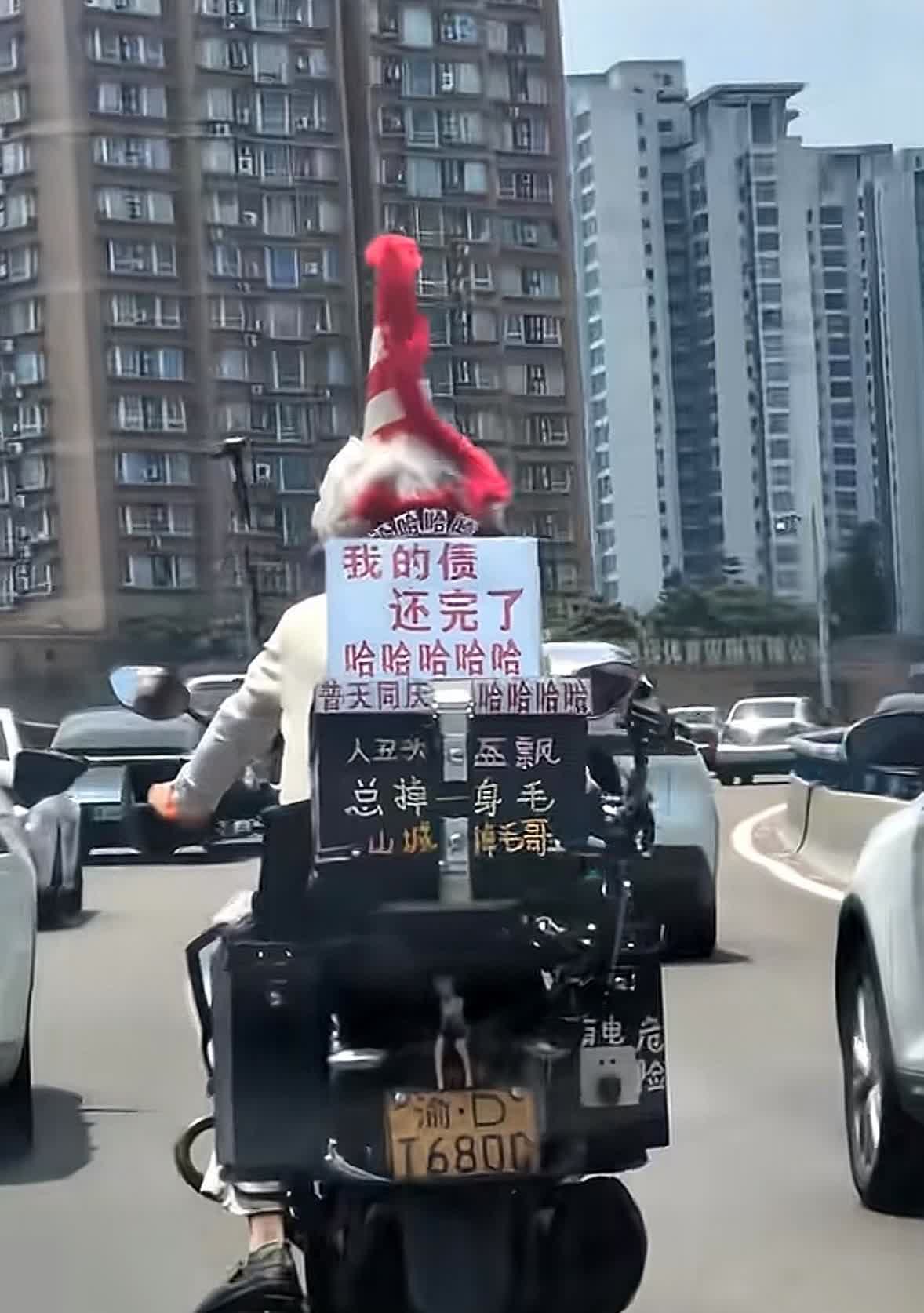 我的债还完了。确实是值得开心的一件事，一名男子在自己的摩托车上写了一块板子，我的