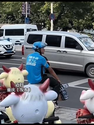 外卖小哥取餐出来，结果看到自己原本停在路边的电动车，已经被装上了拖车。他没有哭