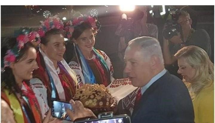 内塔尼亚胡和他的妻子，一起面对戴花美女，一起撒花瓣。鲜花是好东西，可以让美女更赏