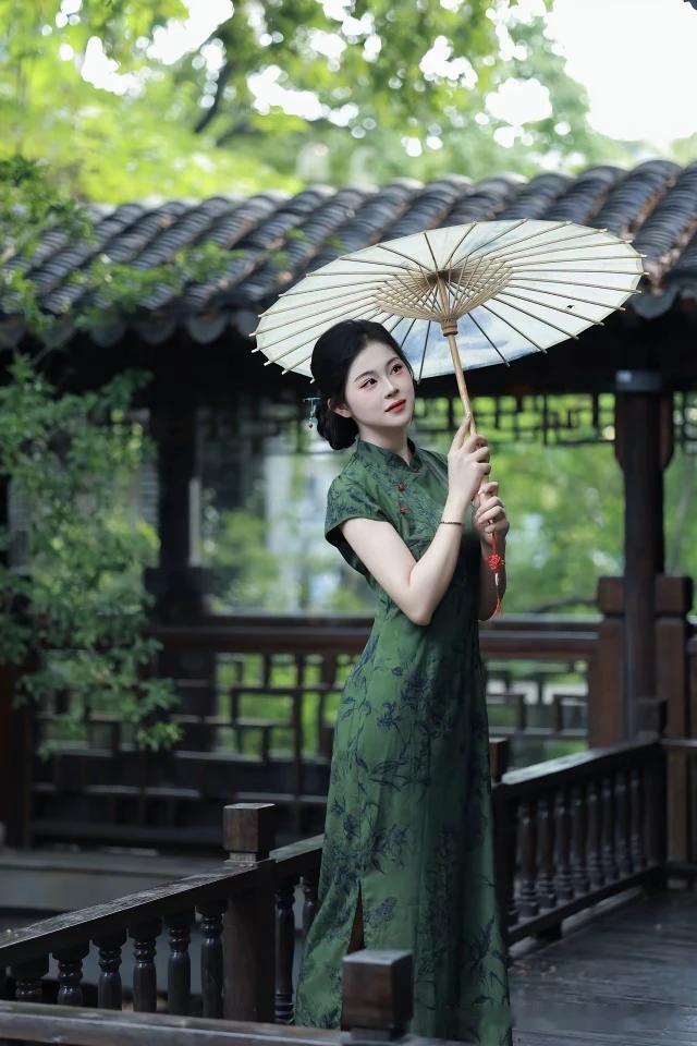 《江南伞韵》作者/淡淡兰花香晨光漫洒水乡幽，素伞旗袍倚岸楼。小船划破