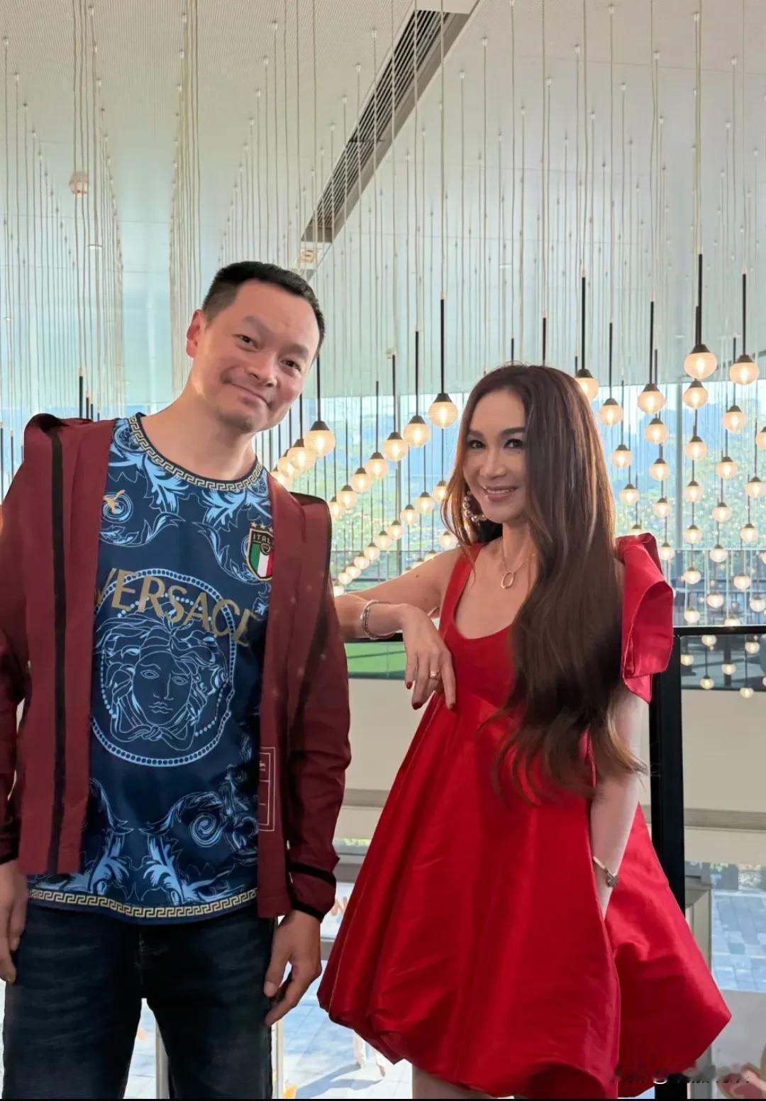 温碧霞现身深圳出席活动，穿着一件红色露肩短裙，脚上穿了一双夏季的高跟凉鞋，长发披