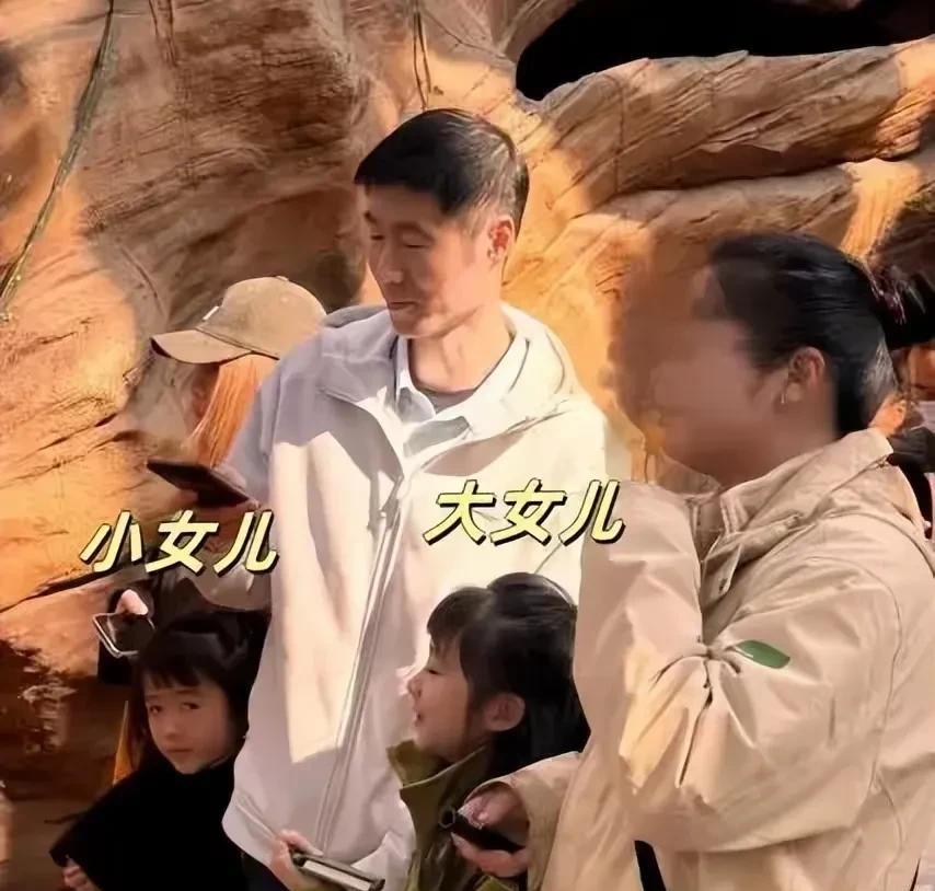 王励勤和一家人出行，两个女儿长的很乖巧。王励勤一定是暖爸，两个女儿都粘着他