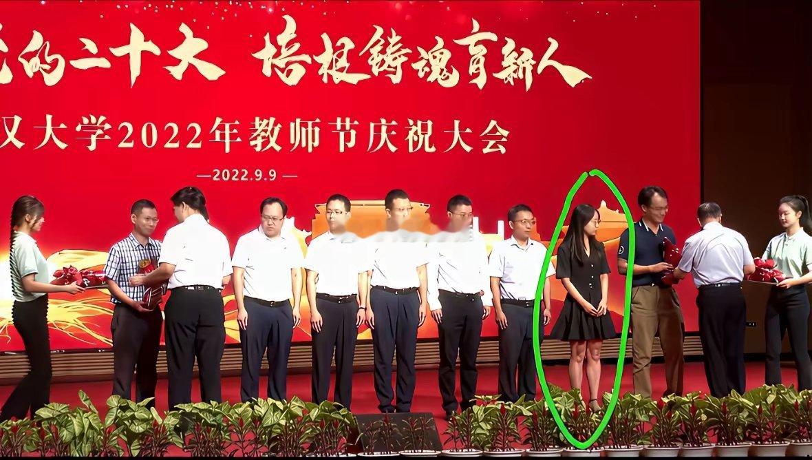 教师节庆祝大会颁奖台上，台上清一色男教师只有曾梦琪一个女教授付人事处长在台下深情