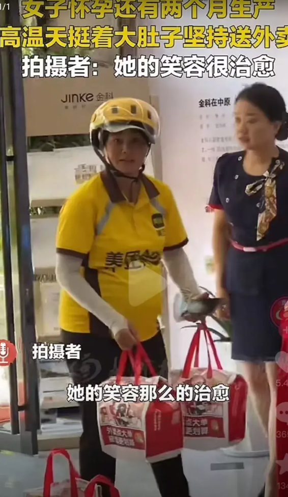 一个外卖员，顶着烈日高温，挺着大肚子，双手提着外卖，旁边还放两个，刚进写字楼大厅