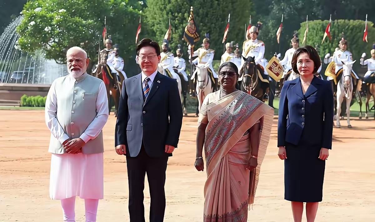 韩国总统李在明访问印度，印度为其举行欢迎仪式，欢迎仪式上站在李在明和夫人金惠景中