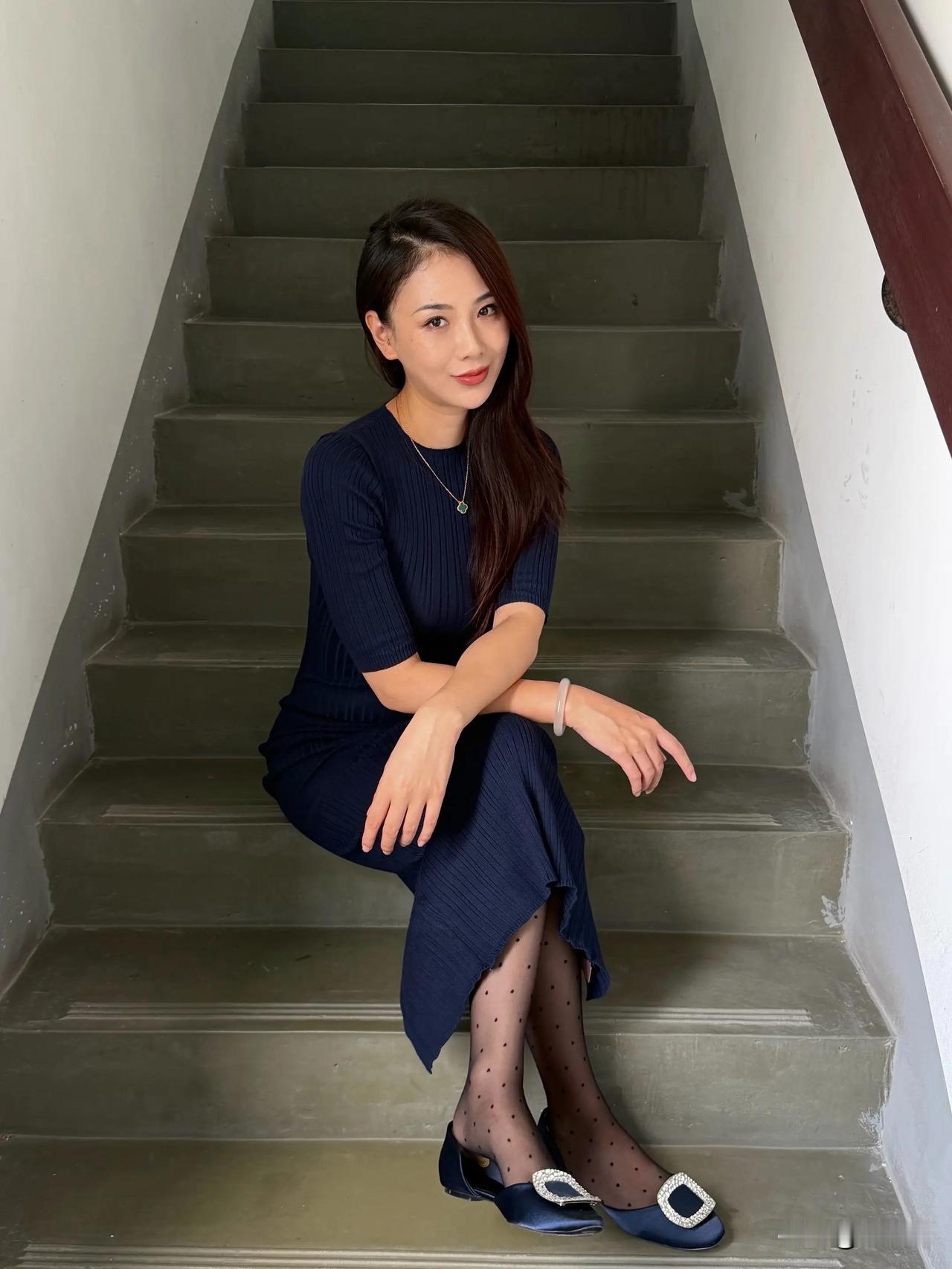 一个女孩坐在楼梯上微笑。