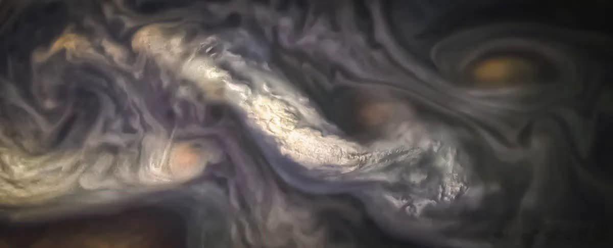 目睹NASA朱诺任务拍摄的这一戏剧性特写中，高空云层在木星上空飞速掠过的催眠