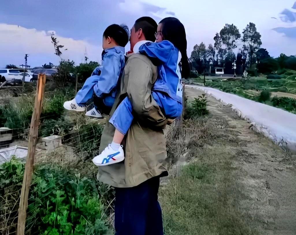 没有保姆随行，也没有大牌高定，周一围把儿子扛在肩头，手里还紧紧牵着大女儿。朱