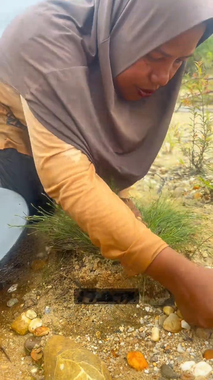 草下暗藏金沙。注意看，女子在河边发现一堆野草，这一眼不简单，她立刻起疑，这草下