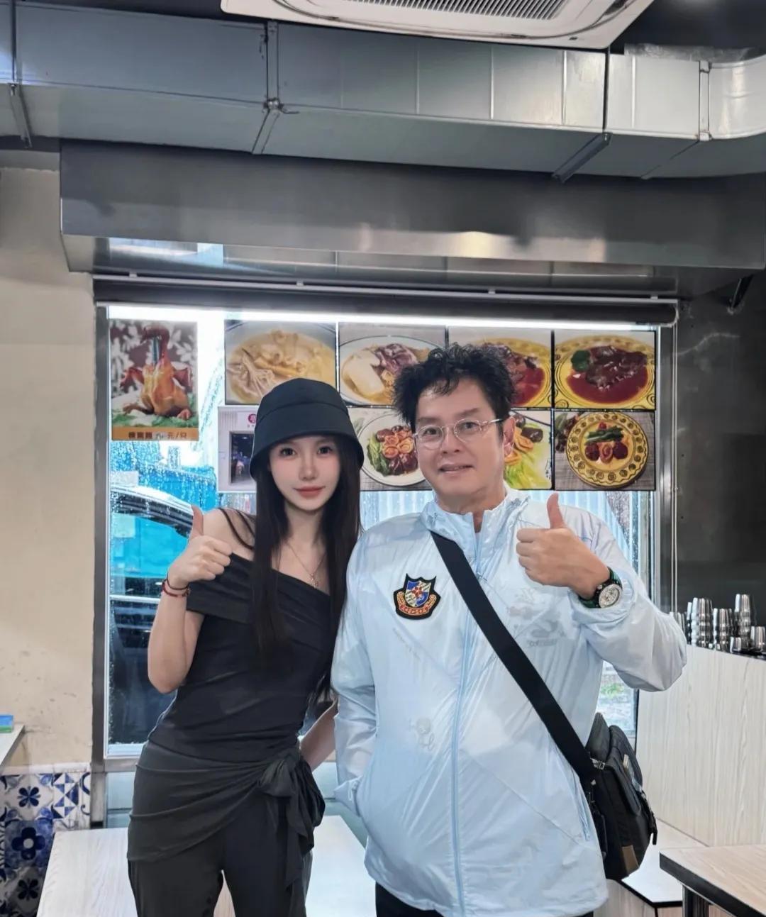 谭咏麟和好友现身澳门某面馆，享受美食。与粉丝同框，画面中的他穿着风衣，烫着小卷发