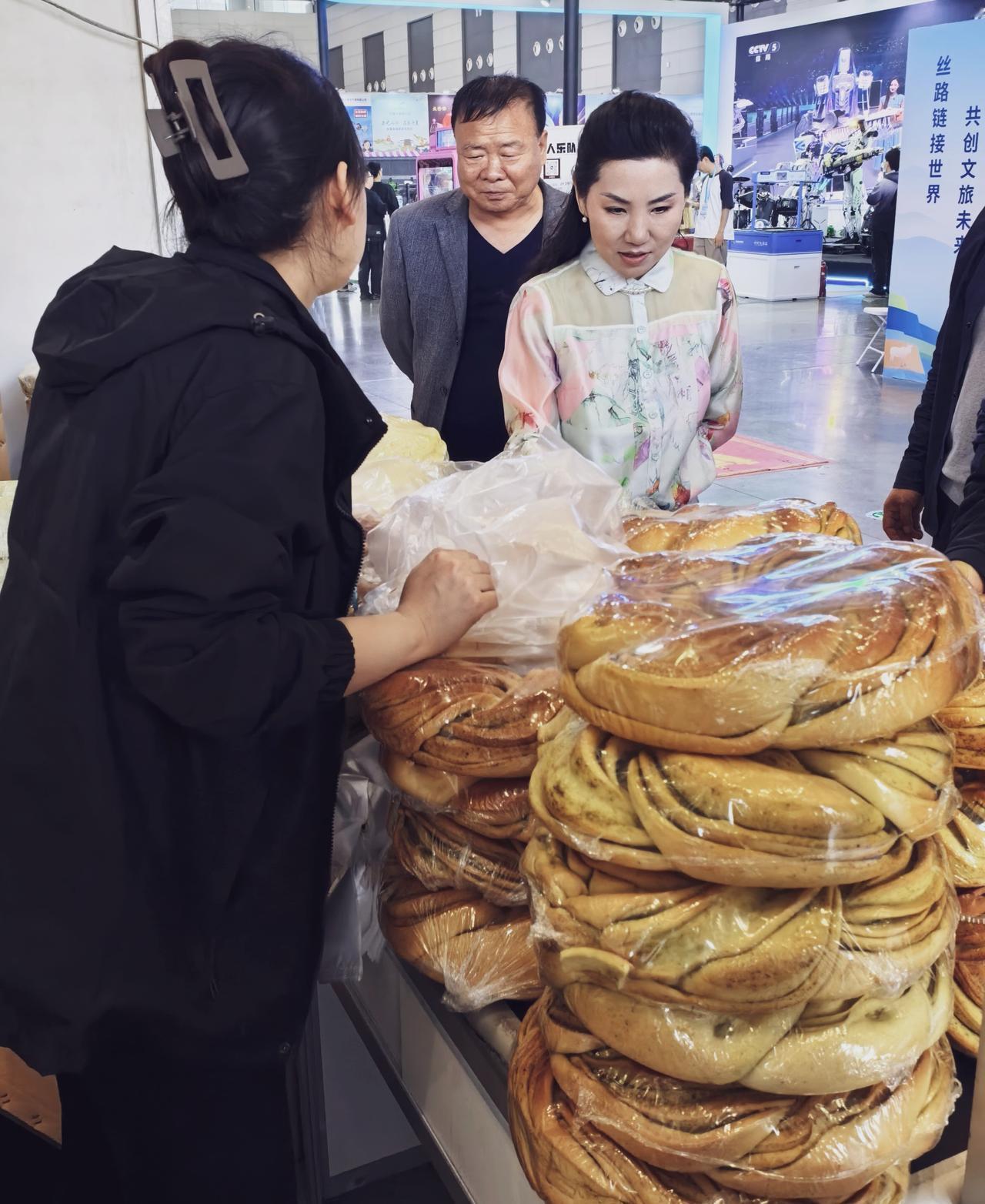 看着像花环，吃起来比面包还香。展台上大饼堆成小山，排队的人绕了两圈，有人说是新疆