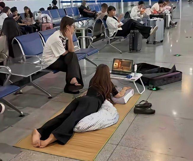 在候车大厅，我目睹了这样一幕。一位美女把凉席铺在地上，随后惬意地躺了上去，旁若无